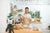 Man standing in the kitchen and cooking while learning online how to cook.